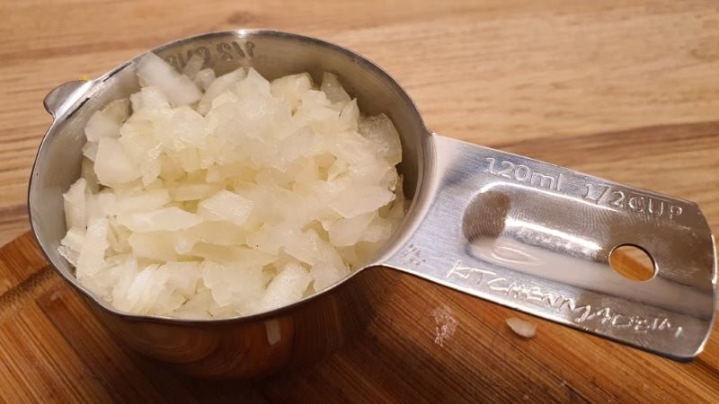 Measuring 1/2 cup chopped onions for egg salad