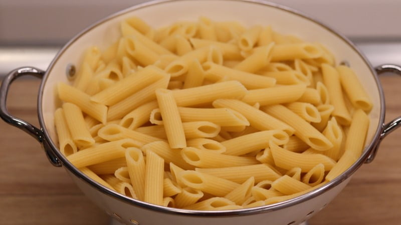 Cooked penne pasta in colander