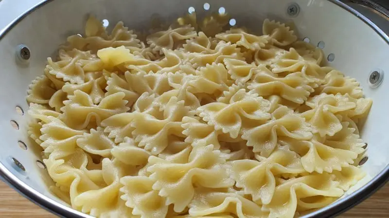 Coocked farfalle pasta in colander